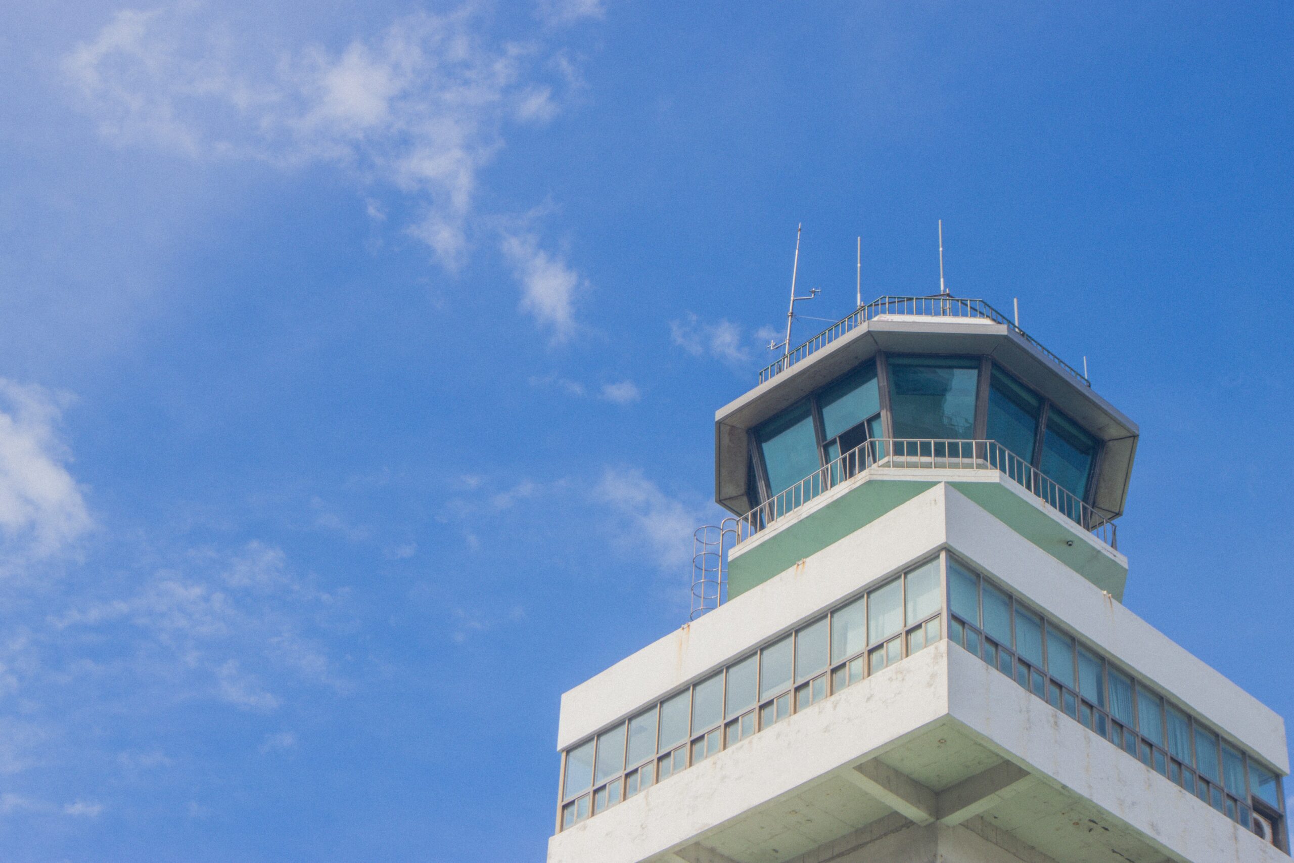 Airport control tower against blue sky representing FAA air traffic control operations